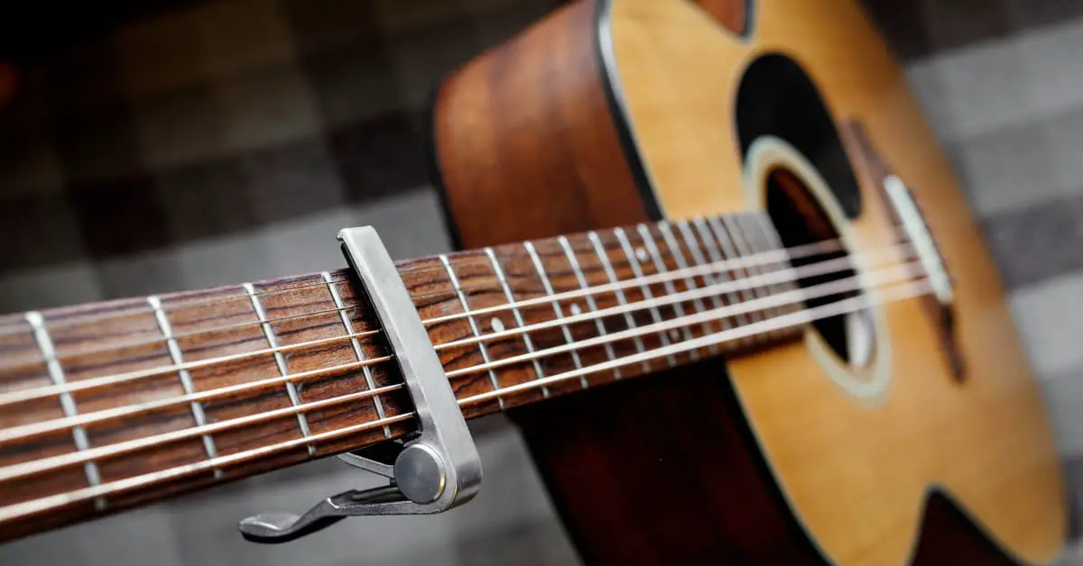 angled view of a guitar from neck down with capo on